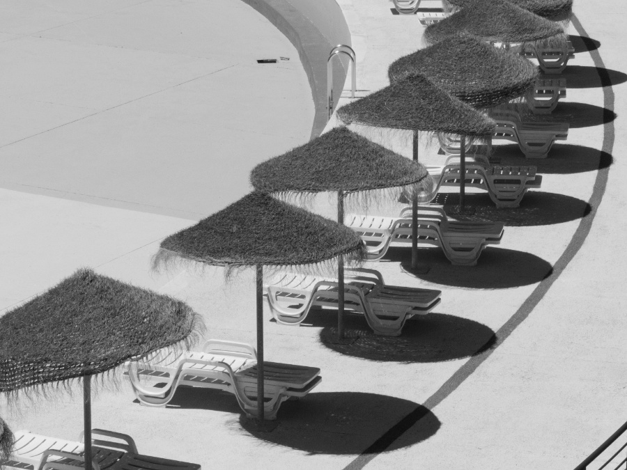 Leeg zwembad met parasols in zwart-wit